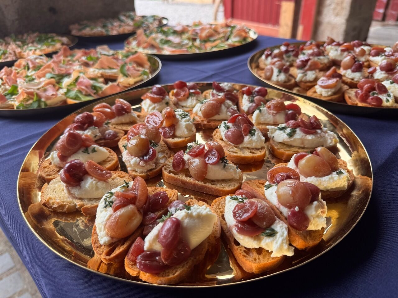 Whipped feta crostini with honey-roasted grapes on a gold platter