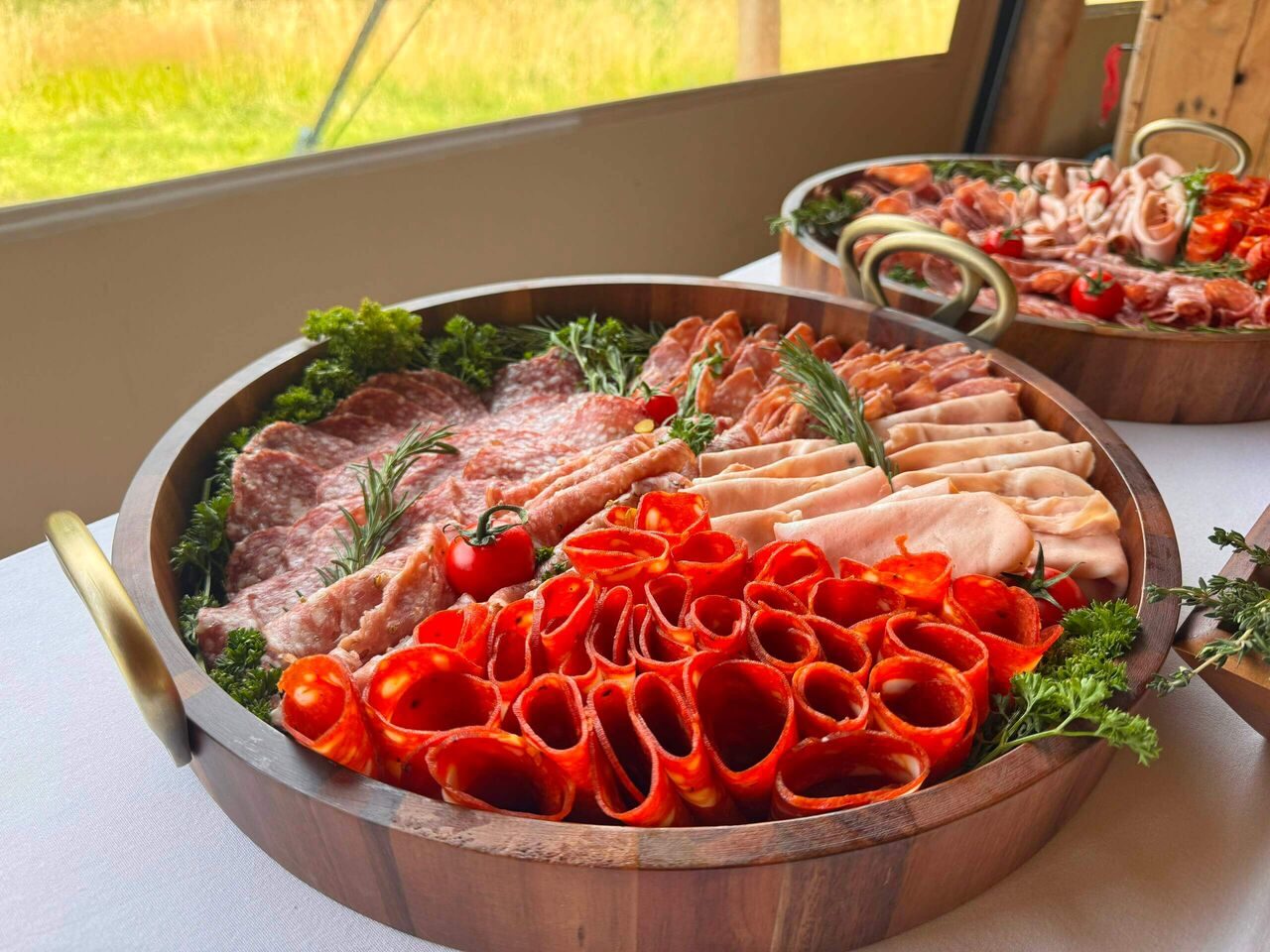 Italian cured meats and roasted peppers in a wooden serving bowl
